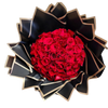 A bouquet of red roses with green leaves, arranged with a black and gold ribbon.