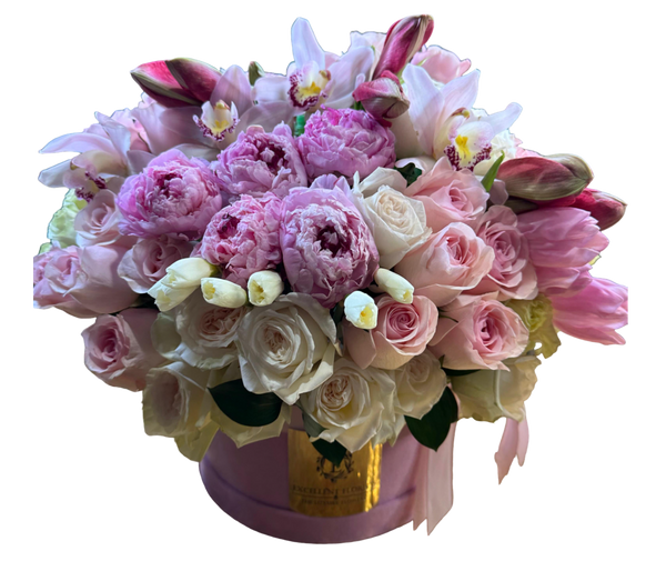 A luxurious floral arrangement in a pink velvet box featuring pink peonies, soft blush roses, vibrant tulips, and delicate pink cymbidium orchids.