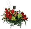 A floral centerpiece featuring red roses, green lilies, gold-colored pinecones, and red berries, arranged in a clear vase with Christmas greens.